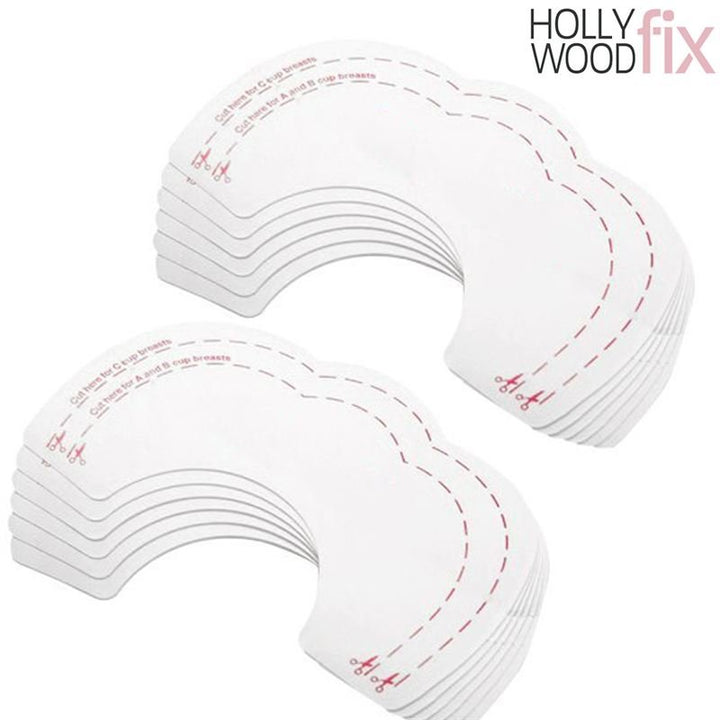 Ein Stapel Fashiongirl Breast Tape Hollywood Fix Instant Lift – 10 Stück, angeordnet in zwei Stapeln, zeigt halbmondförmige Streifen mit gestrichelten Linien und Scheren-Symbolen, die anzeigen, wo geschnitten werden muss.