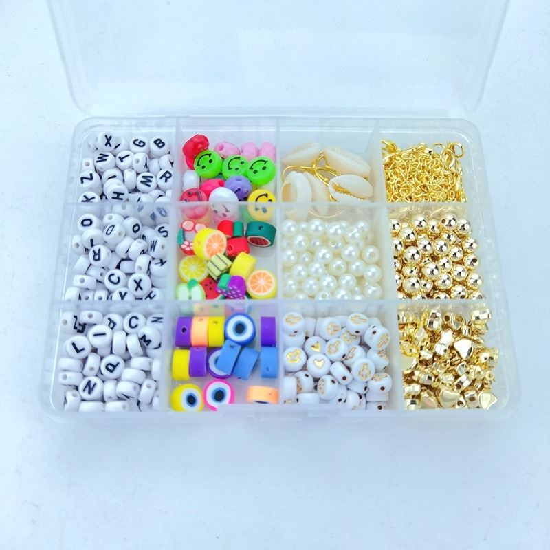 Das Fashiongirl Clay Beads / Heishi Beads Arona Kit ist ein KREA DIY-Schmuck-Set mit 12.000 verschiedenen Perlen, darunter Buchstaben, bunte Rundperlen, Perlen, Fruchtscheibenperlen, metallische Goldperlen und goldene Verschlüsse in einer Aufbewahrungsbox mit 12 Fächern.