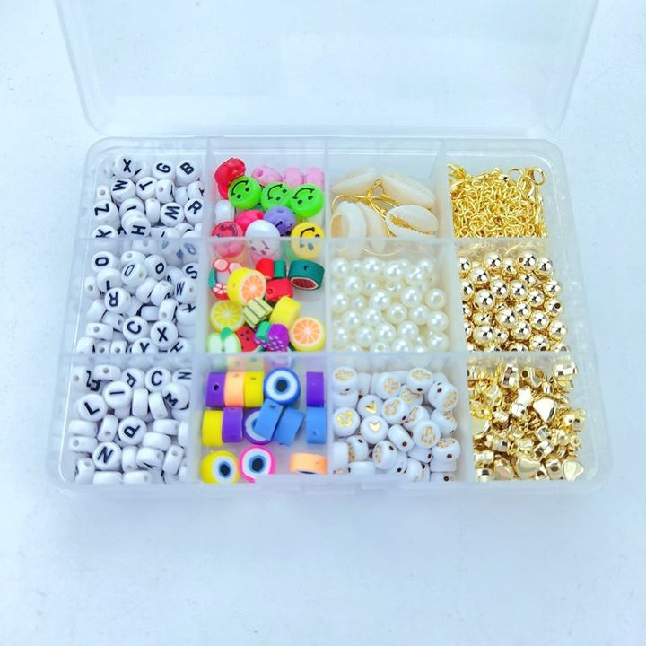 Das Fashiongirl Clay Beads / Heishi Beads Arona Kit ist ein KREA DIY-Schmuck-Set mit 12.000 verschiedenen Perlen, darunter Buchstaben, bunte Rundperlen, Perlen, Fruchtscheibenperlen, metallische Goldperlen und goldene Verschlüsse in einer Aufbewahrungsbox mit 12 Fächern.