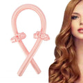 Die Fashiongirl Heatless Hair Curlers in Pink werden mit zwei passenden Haargummis geliefert und neben einer Frau mit langen, glänzenden kastanienbraunen Locken abgebildet – für schöne Locken ohne Hitze.
