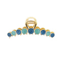 Die SOHO Becca Hair Claw – Ocean von SOHO verfügt über ein goldenes Metalldesign mit abwechselnd runden blauen und türkisfarbenen Steinen entlang der Kante und eignet sich ideal zum Fixieren Ihrer Frisur.