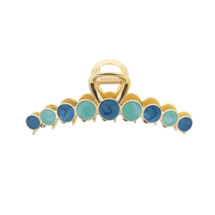 Die SOHO Becca Hair Claw – Ocean von SOHO verfügt über ein goldenes Metalldesign mit abwechselnd runden blauen und türkisfarbenen Steinen entlang der Kante und eignet sich ideal zum Fixieren Ihrer Frisur.