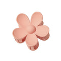 Die SOHO Bloom Hair Claw – Peach von SOHO hat die Form einer beige-rosa Blüte mit fünf abgerundeten Blütenblättern und einem niedlichen Zentrum – ein bezauberndes Haaraccessoire für jeden Anlass.