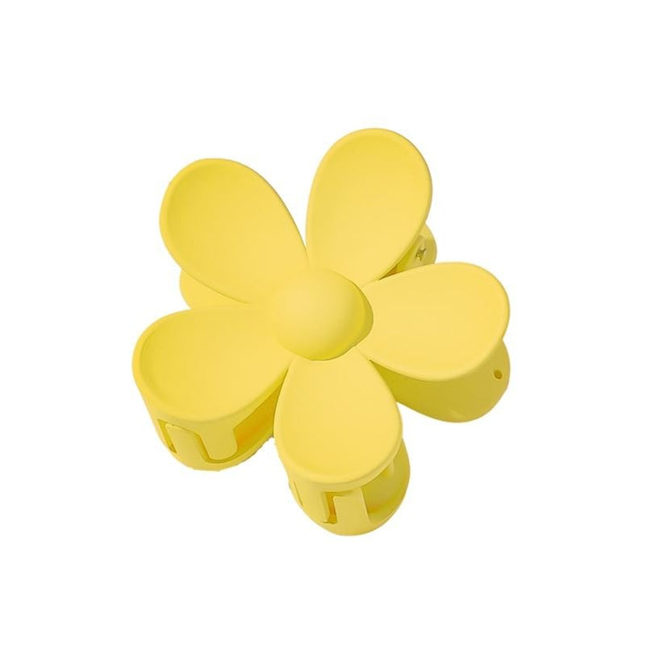Die SOHO Bloom Hair Claw – Yellow von SOHO ist ein blütenförmiges Haaraccessoire mit fünf abgerundeten Blütenblättern, das von oben auf weißem Hintergrund abgebildet ist.