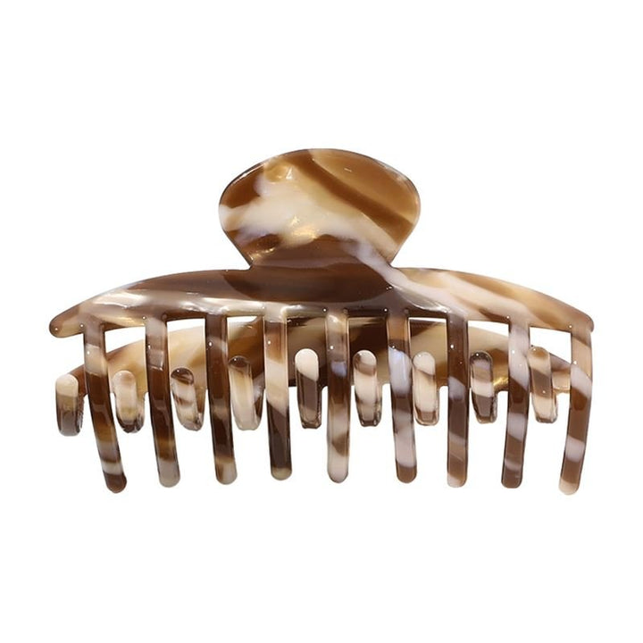 The SOHO Gaja Hair Claw in Brown Marble features wide, curved teeth and a rounded top—perfect for securing updos in style.