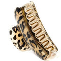 Die SOHO Hair Claw – Leopard von SOHO ist eine große gold-schwarze Haarspange mit Leopardenmotiv, hergestellt aus strapazierfähigem Acrylkunststoff und mit gebogenen Zähnen für sicheren Halt.