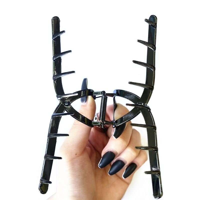 Eine Hand mit langen, mattschwarzen Nägeln hält die SOHO Iva Metal Hair Claw in Schwarz, ein großes Accessoire von SOHO mit weit auseinanderstehenden Zinken – perfekt zum Fixieren eines unordentlichen Dutts – vor einem weißen Hintergrund.