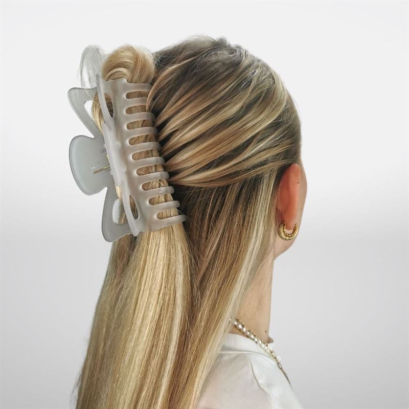 A woman with long blonde hair in a half-up twist, secured by the SOHO Jelly Hair Claw in Cloudy Grey, suitable for all hair types. She wears gold hoop earrings and a pearl necklace, viewed from behind.
