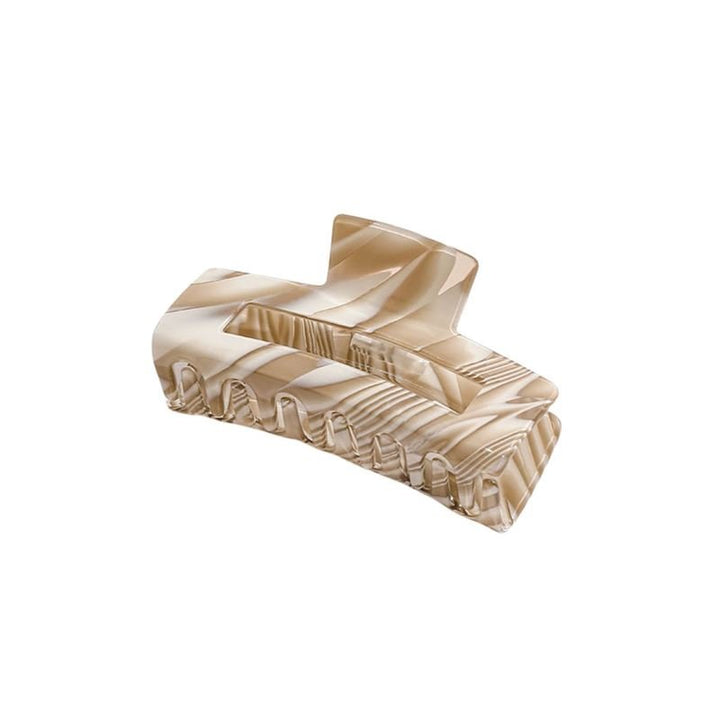 The SOHO Kaisa Hair Claw - Brown by SOHO is a stylish rectangular acetate clip with beige and cream marbling, interlocking teeth, and a modern design, shown on a white background.