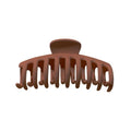 Die SOHO Kana Hair Claw in Bark Brown von SOHO ist eine Haarspange aus Kunststoff mit gebogenen, ineinandergreifenden Zähnen für einen starken Halt. Sie wird von vorne auf weißem Hintergrund gezeigt und ist für alle Haartypen geeignet.