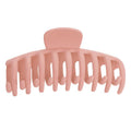 Die SOHO Kana Hair Claw in Peach Beige verfügt über breite, abgerundete Zinken und ein gebogenes Design für einen sicheren Halt bei allen Haartypen. Sie besteht aus rosa Kunststoff und wird vor einem weißen Hintergrund gezeigt.