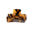 Die SOHO Leia Mini Hair Claw – Tortoise von SOHO verfügt über ein braunes Schildpattmuster, ein geschwungenes Design und ineinandergreifende Zähne für sicheren Halt – perfekt als kleine Haarspange für einfaches Styling und um das Haar an Ort und Stelle zu halten.