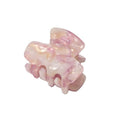 Die SOHO Loa Mini Hair Claw – Blush von SOHO zeichnet sich durch ein marmoriertes Design in Blush Pink, eine glänzende Oberfläche, gebogene Zinken und eine rechteckige Form aus – perfekt als kleine Haarklammer für alltägliche Eleganz.