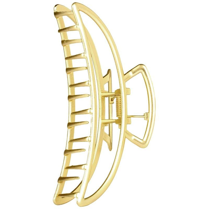 The SOHO Lyra Large Metal Hair Claw in gold features an open geometric design with curved, parallel bars and a central spring—ideal for elegant hairstyles or securing messy buns.