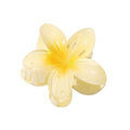 Die SOHO Moana Hair Claw – Yellow ist ein hellgelbes, blumenförmiges Haaraccessoire von SOHO mit fünf glänzenden Blütenblättern und einem Federverschluss, inspiriert von der Plumeria-Blume – ideal als Sommeraccessoire.