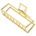 Die SOHO Niba Large Metal Hair Claw in Gold verfügt über offene Stege und ein Federscharnier, das einen sicheren Halt für unordentliche Dutts bietet – ideal für stilvolle, mühelose Looks.