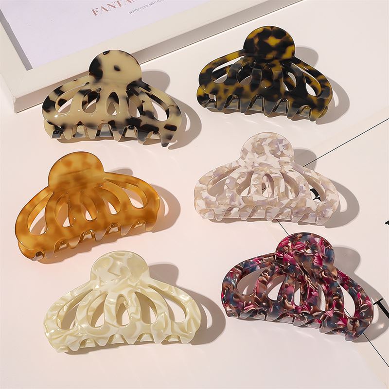 Die SOHO Olivia Hair Claw – Dark Tortoise von SOHO wird zusammen mit sechs einzigartigen Haarspangen mit Marmorierung präsentiert, die in zwei Reihen angeordnet sind. Jede Spange ist in verschiedenen Beige-, Braun-, Schwarz-, Elfenbein-, Weiß- oder Rosatönen gehalten.