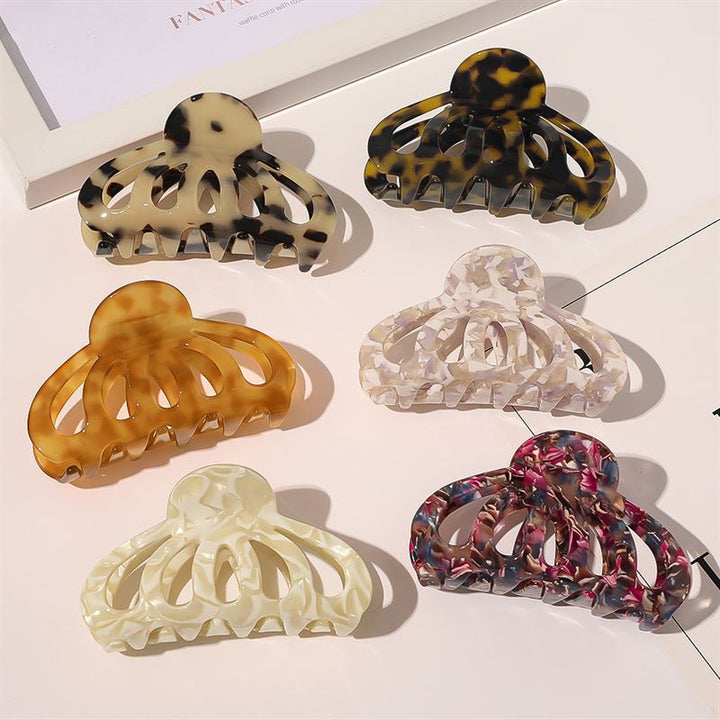 Die SOHO Olivia Hair Claw – Dark Tortoise von SOHO wird zusammen mit sechs einzigartigen Haarspangen mit Marmorierung präsentiert, die in zwei Reihen angeordnet sind. Jede Spange ist in verschiedenen Beige-, Braun-, Schwarz-, Elfenbein-, Weiß- oder Rosatönen gehalten.