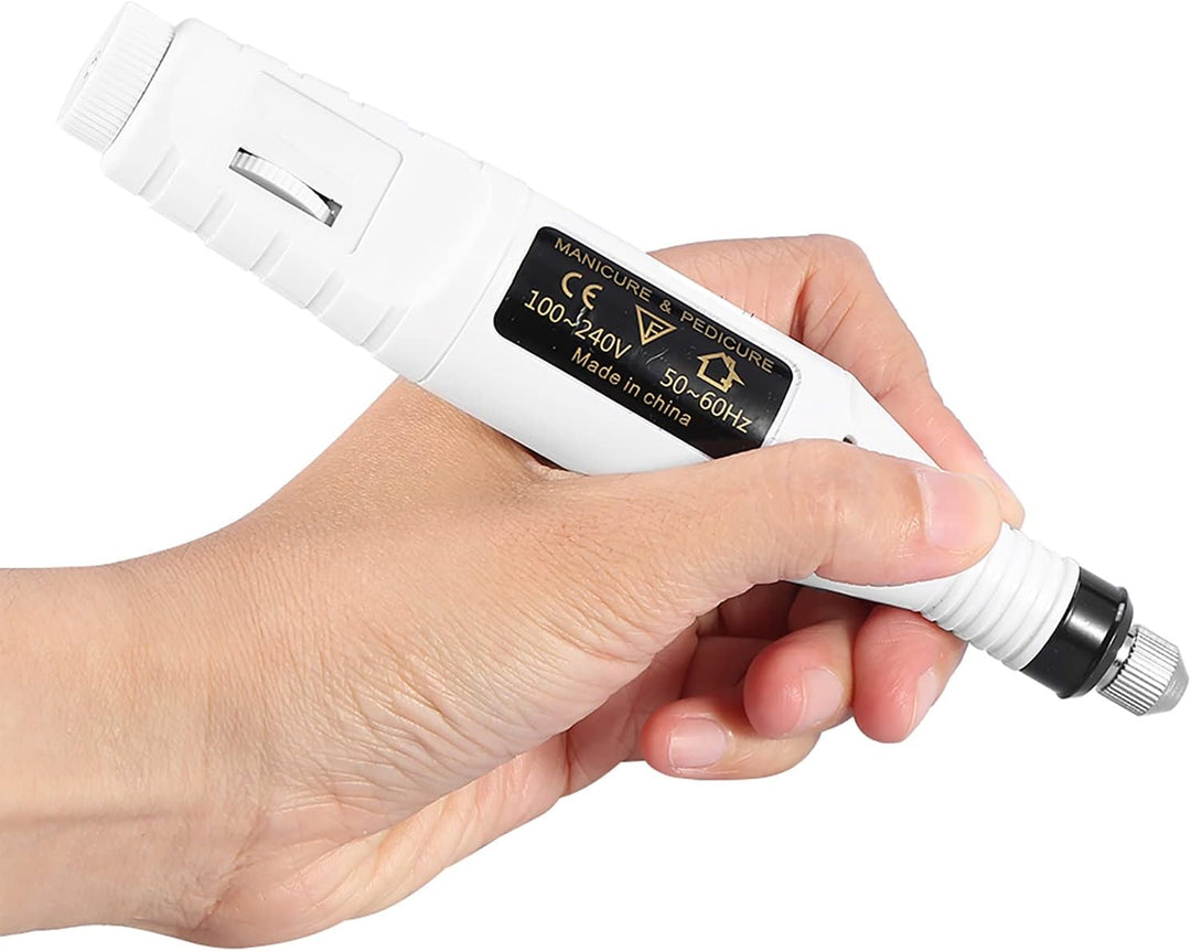 Eine Hand hält die UNIQ Basic 6-in-1 Electric Nail File in Weiß, ein zylindrisches Nagelbohrerset mit einem schwarz-goldenen UNIQ-Label und einem Einstellrad – ein unverzichtbares Werkzeug für jedes Maniküre-Set.