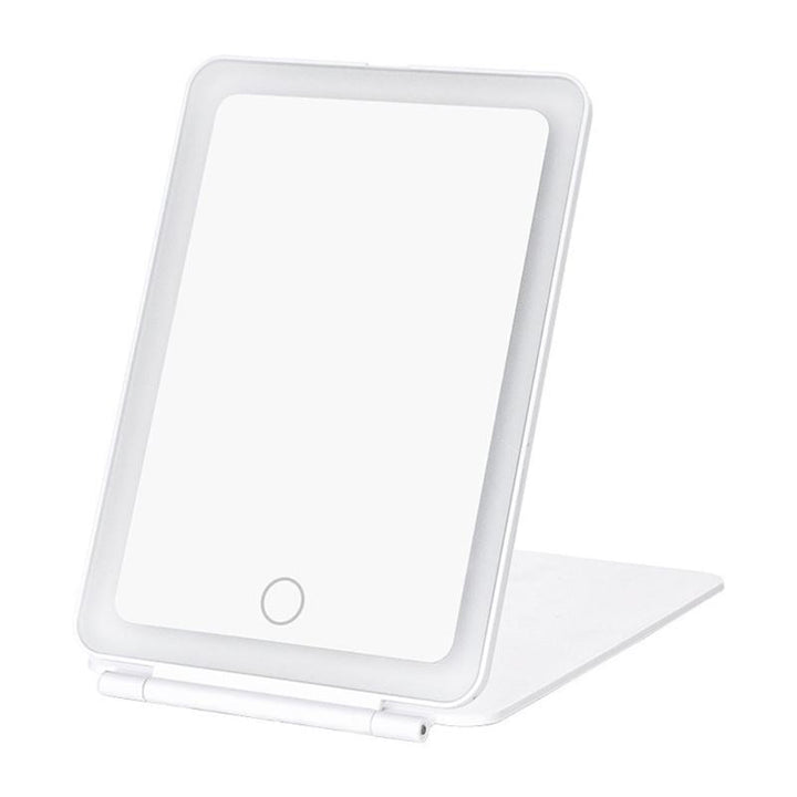 The UNIQ Foldable LED Makeup Mirror in white features a rectangular design with rounded edges, a touch button at the bottom center, and a foldable stand. Its rechargeable, travel-friendly, and made by UNIQ.