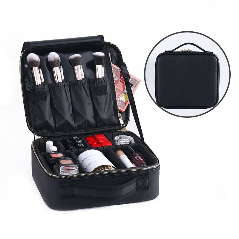 Die UNIQ Make-up-Reisetasche von UNIQ ist eine schwarze Kosmetik- und Toilettentasche mit verstellbaren Fächern, in denen Pinsel und Kosmetika ordentlich verstaut werden können. Sie wird offen gezeigt, um die Make-up-Artikel zu präsentieren, und ein kleineres Bild zeigt die robuste Tasche mit Griff im geschlossenen Zustand.